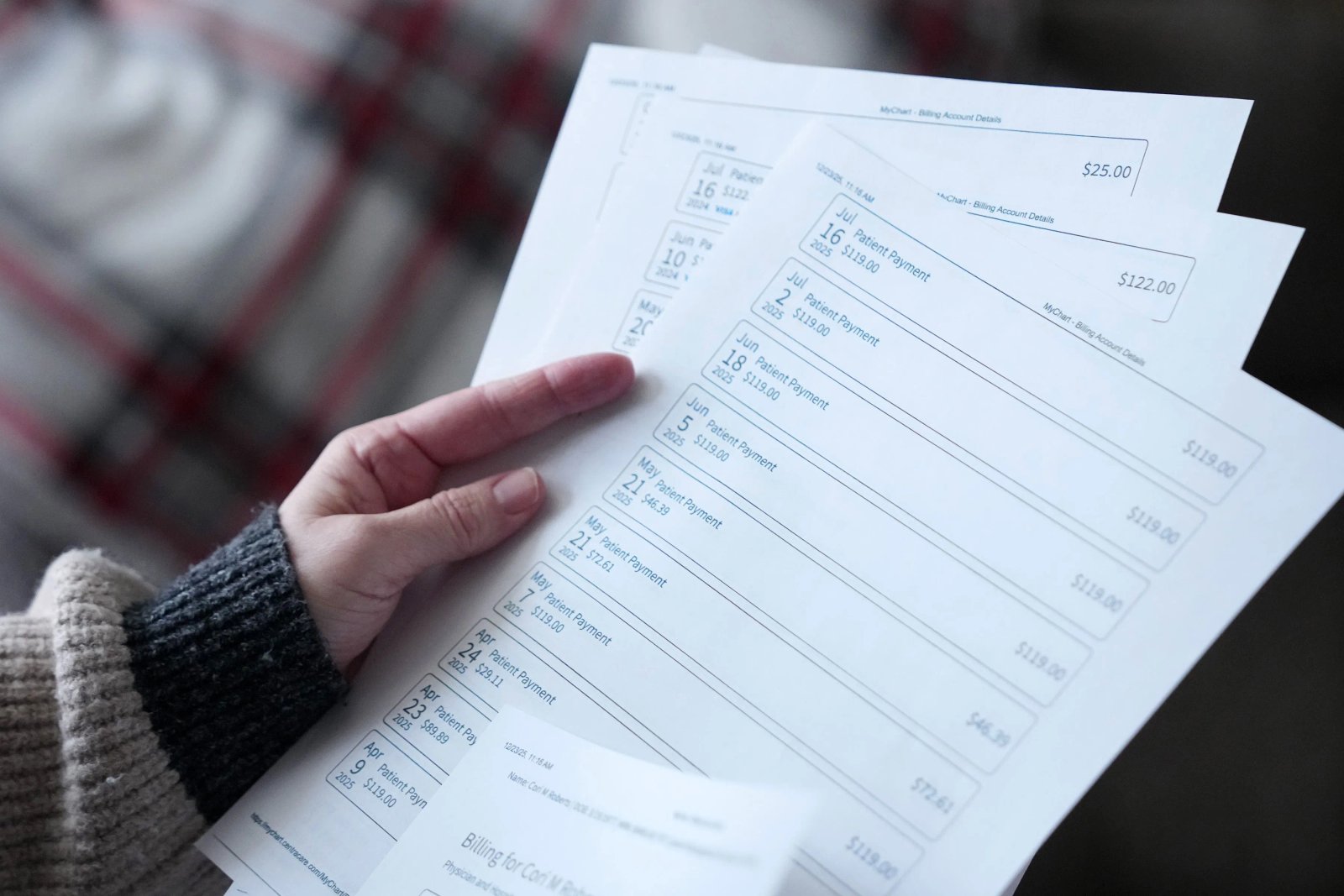 A hand holds at least four sheets of paper printed with the date and amounts of payments. There are 10 payments listed on the clearest page.